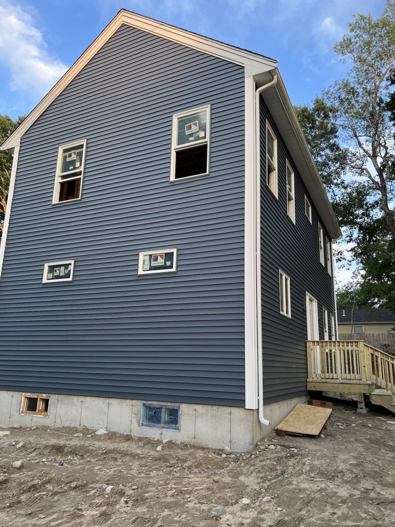 Blue siding with foundation exposed at bottom
