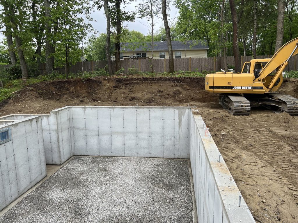 Photo of the new foundation with an excavator to the right of it